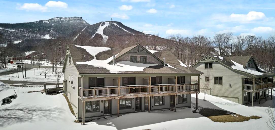 Snow-covered houses with mountains in the background.